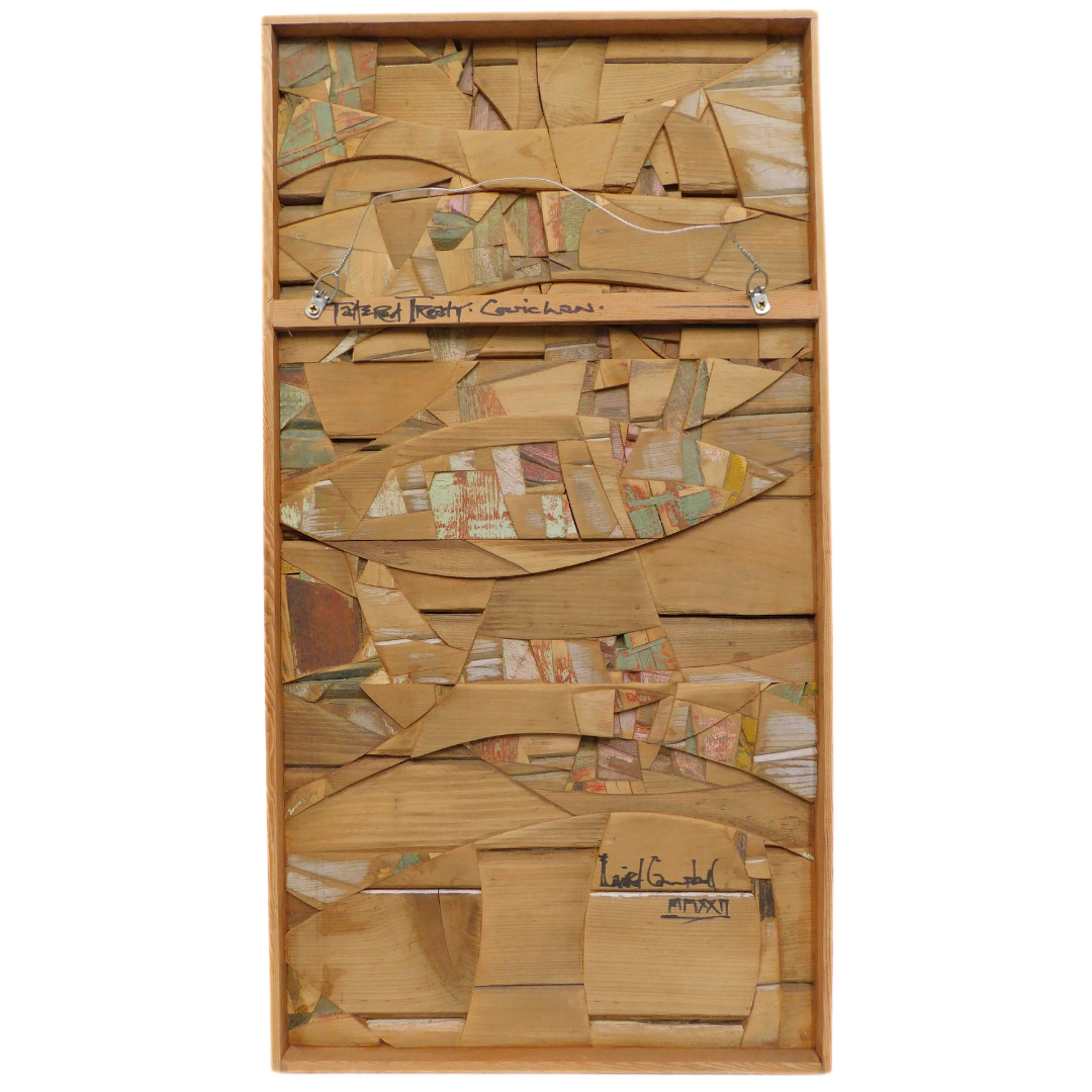 Wooden abstract art piece with cut-out shapes on a white background displaying back of artwork