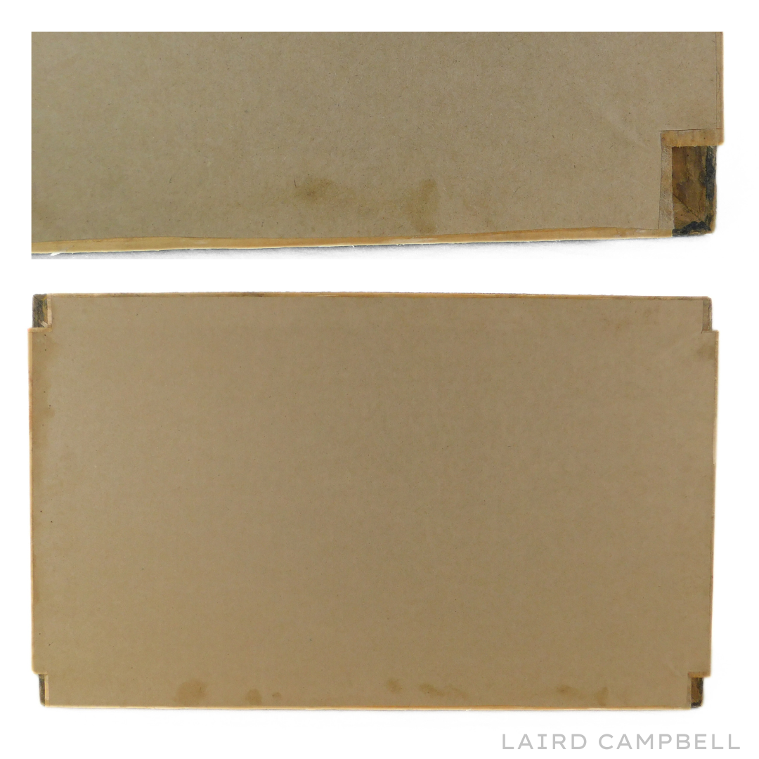 Back view of framed artwork showing  brown cardboard with visible edges.